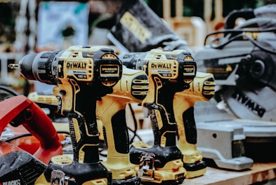 yellow Dewalt hand drills on table
