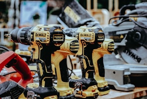 yellow Dewalt hand drills on table