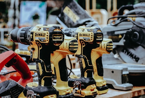 yellow Dewalt hand drills on table