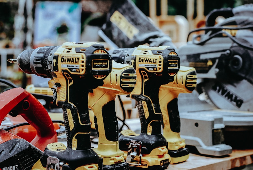 yellow Dewalt hand drills on table