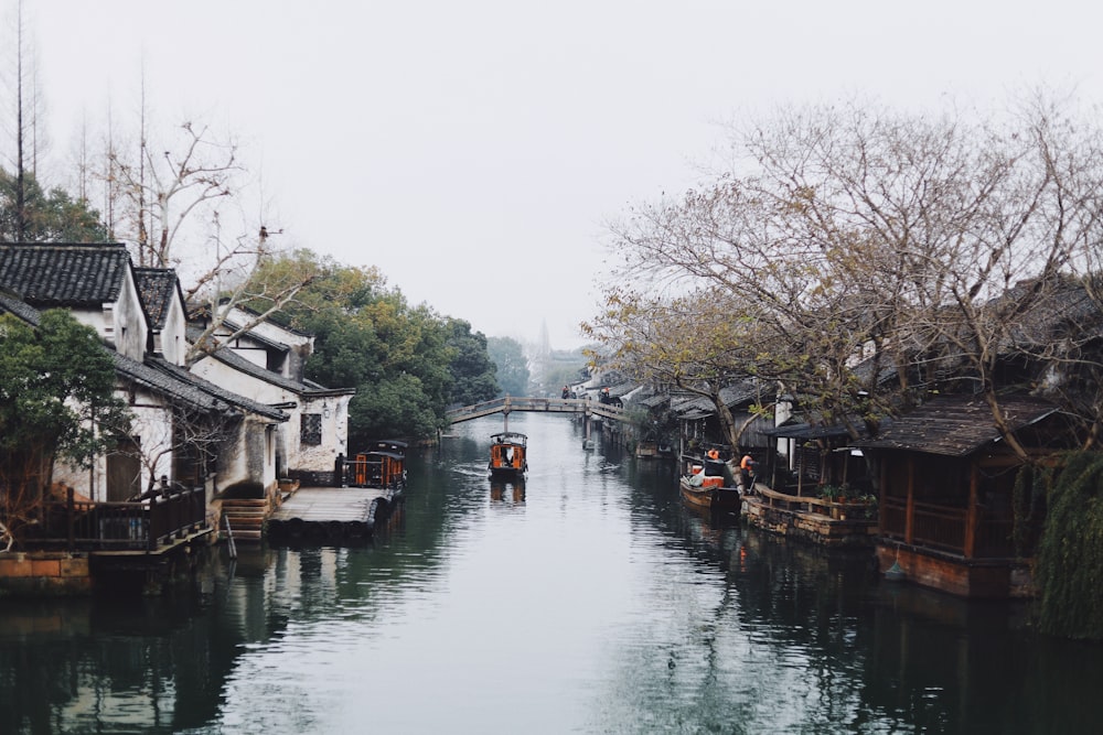 boat floating on canal between houses