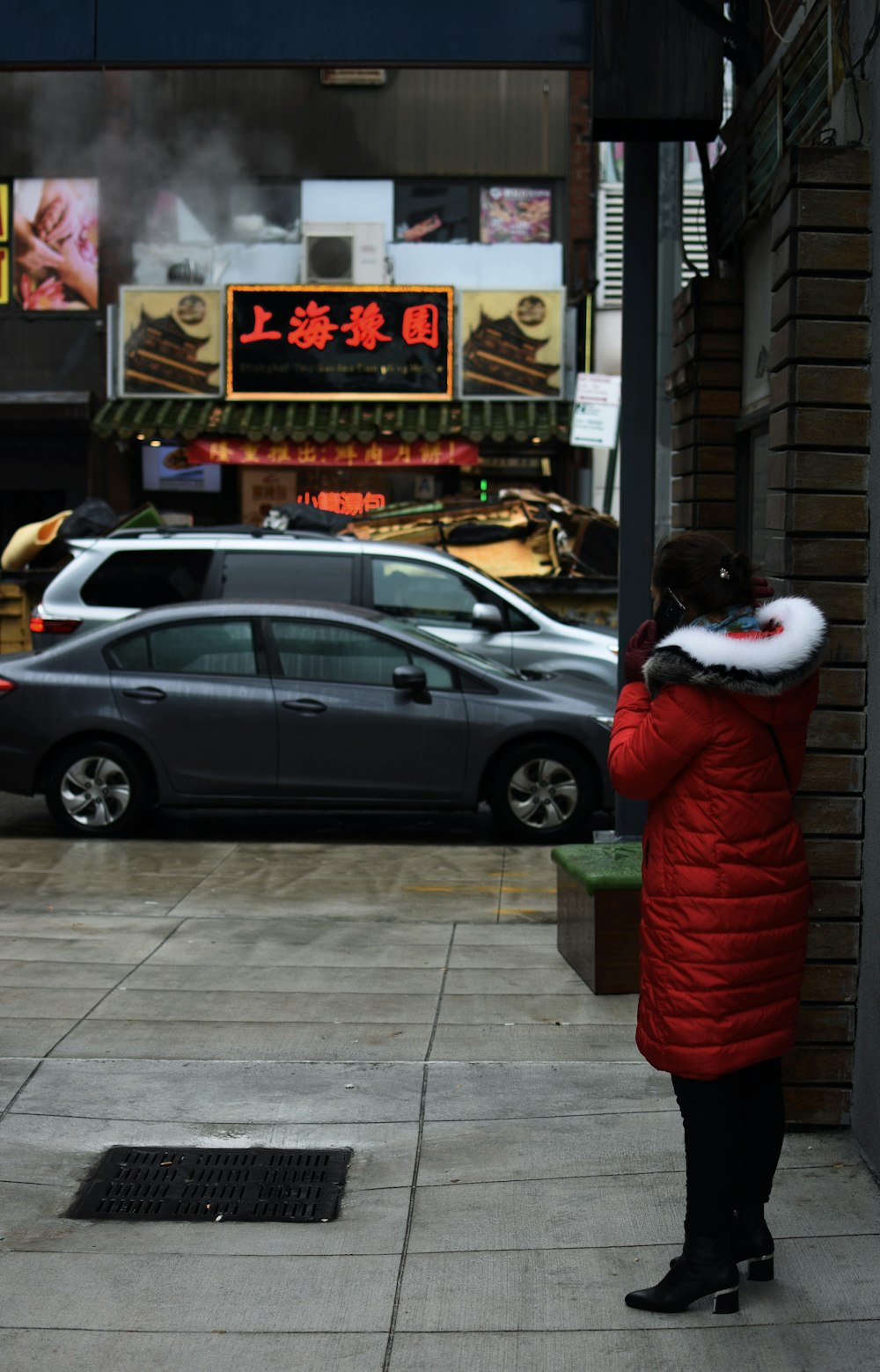 person standing outside building near vehicles