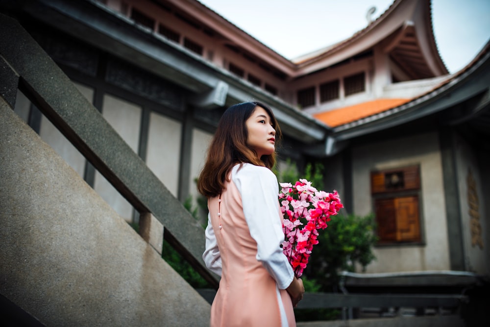 woman holding pink flowers