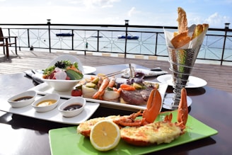 Guests enjoying fresh seafood dishes with a panoramic ocean backdrop