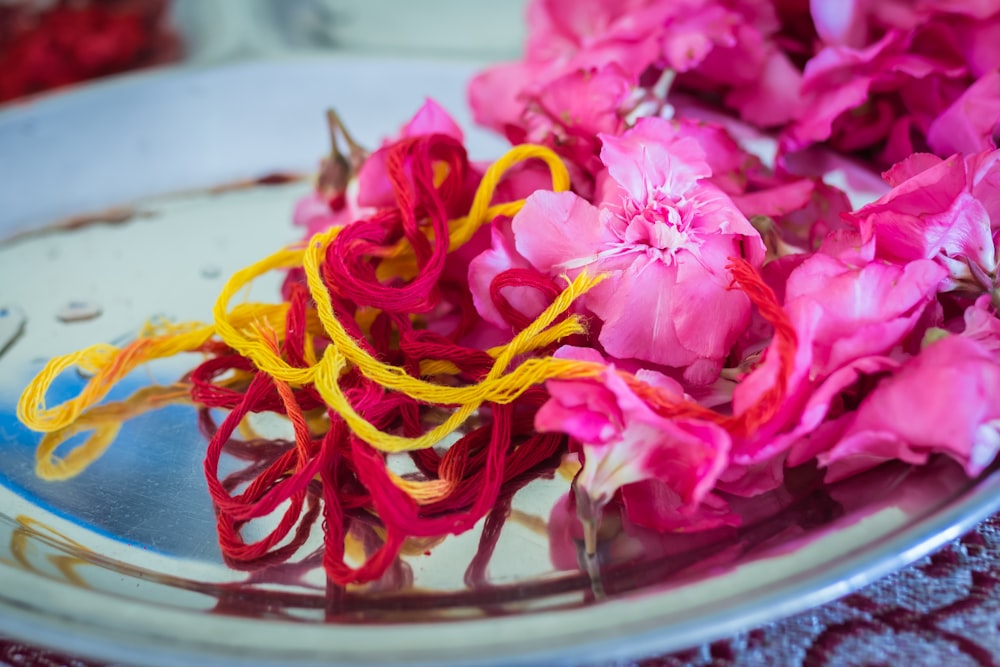 purple-petaled flowers beside pink and yellow threads