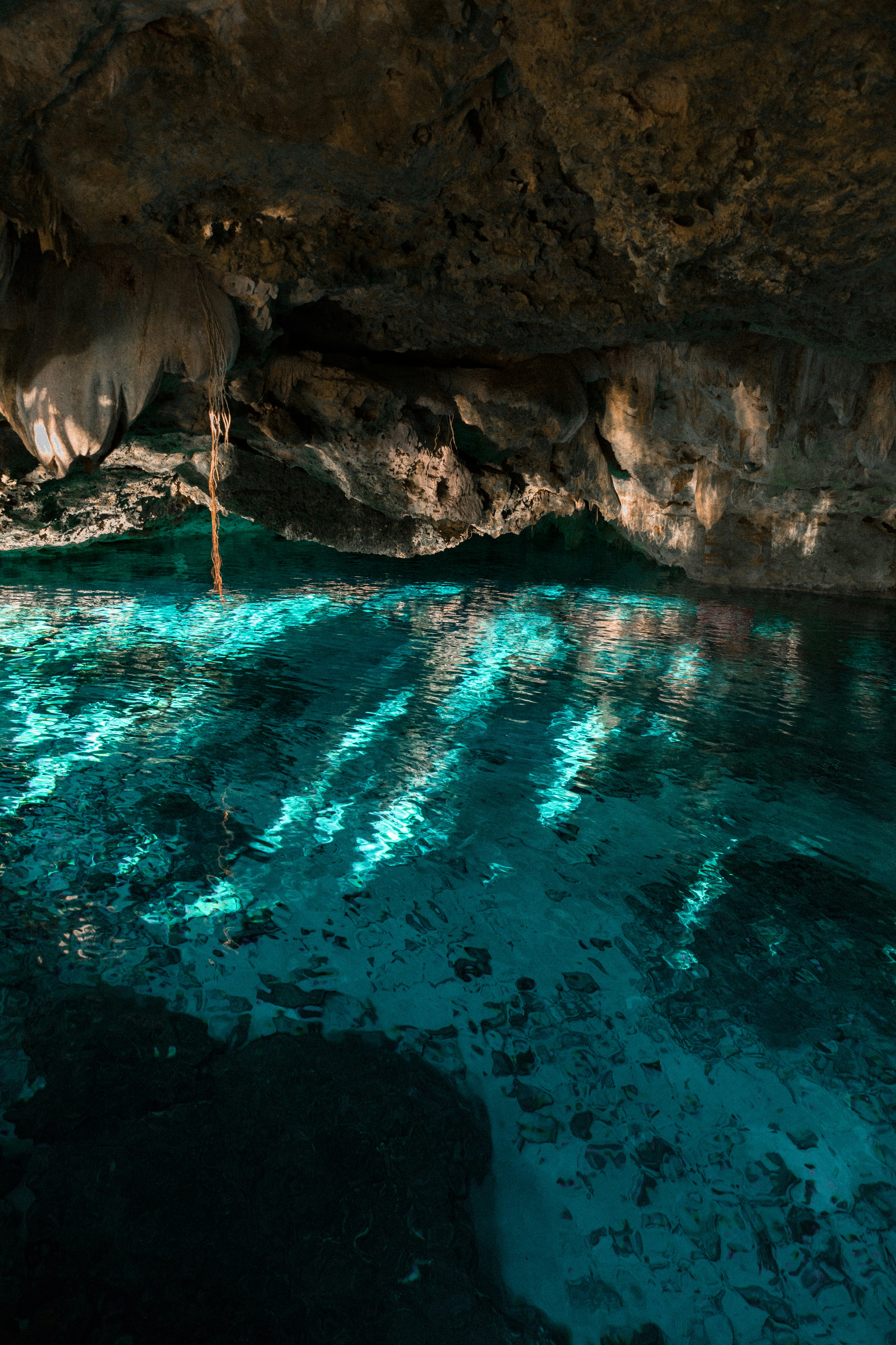 Semi-open cenote with turquoise waters.