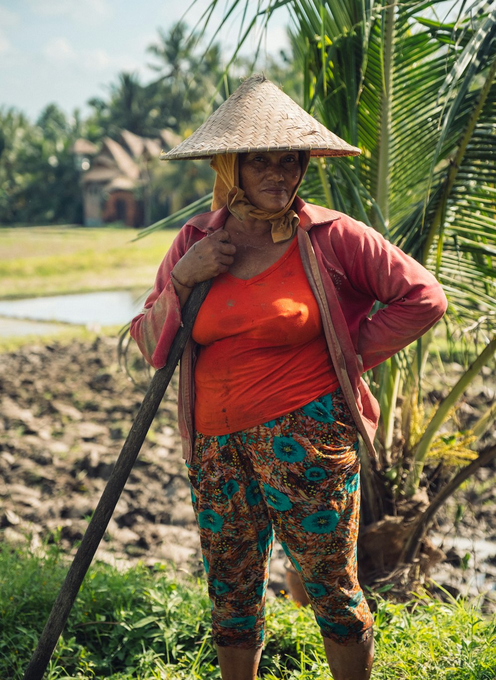 woman wearing red top standing beside coconut plant