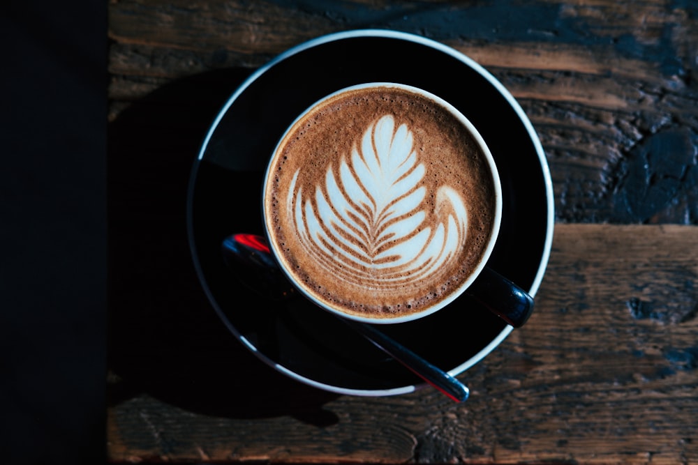 round black ceramic teacup with saucer containing coffee