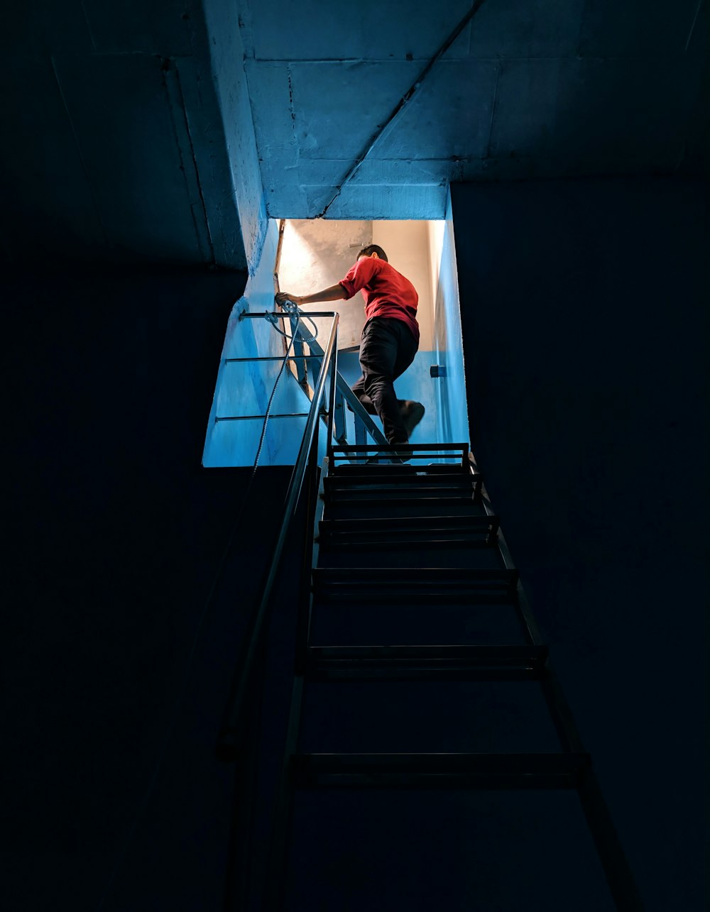 man in red shirt climbing stairs