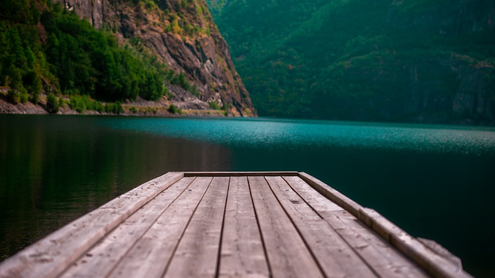 wooden dock facing body of water and mountain
