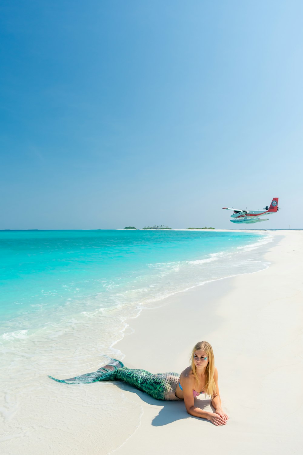 blonde-haired woman wearing green mermaid costume on seashore