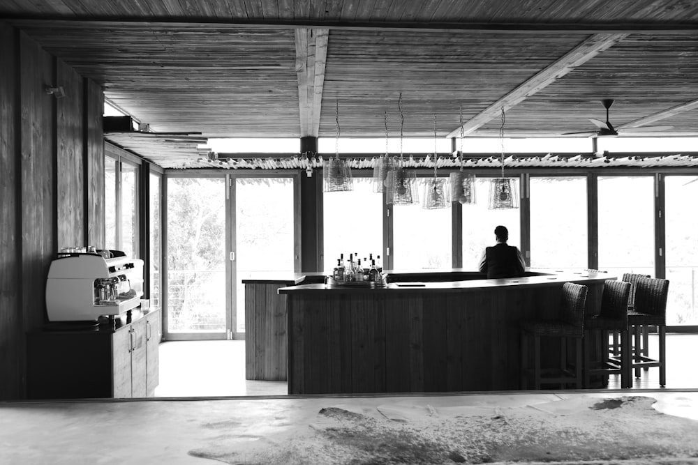 Homme debout à l’intérieur du comptoir du bar sur une photo en niveaux de gris