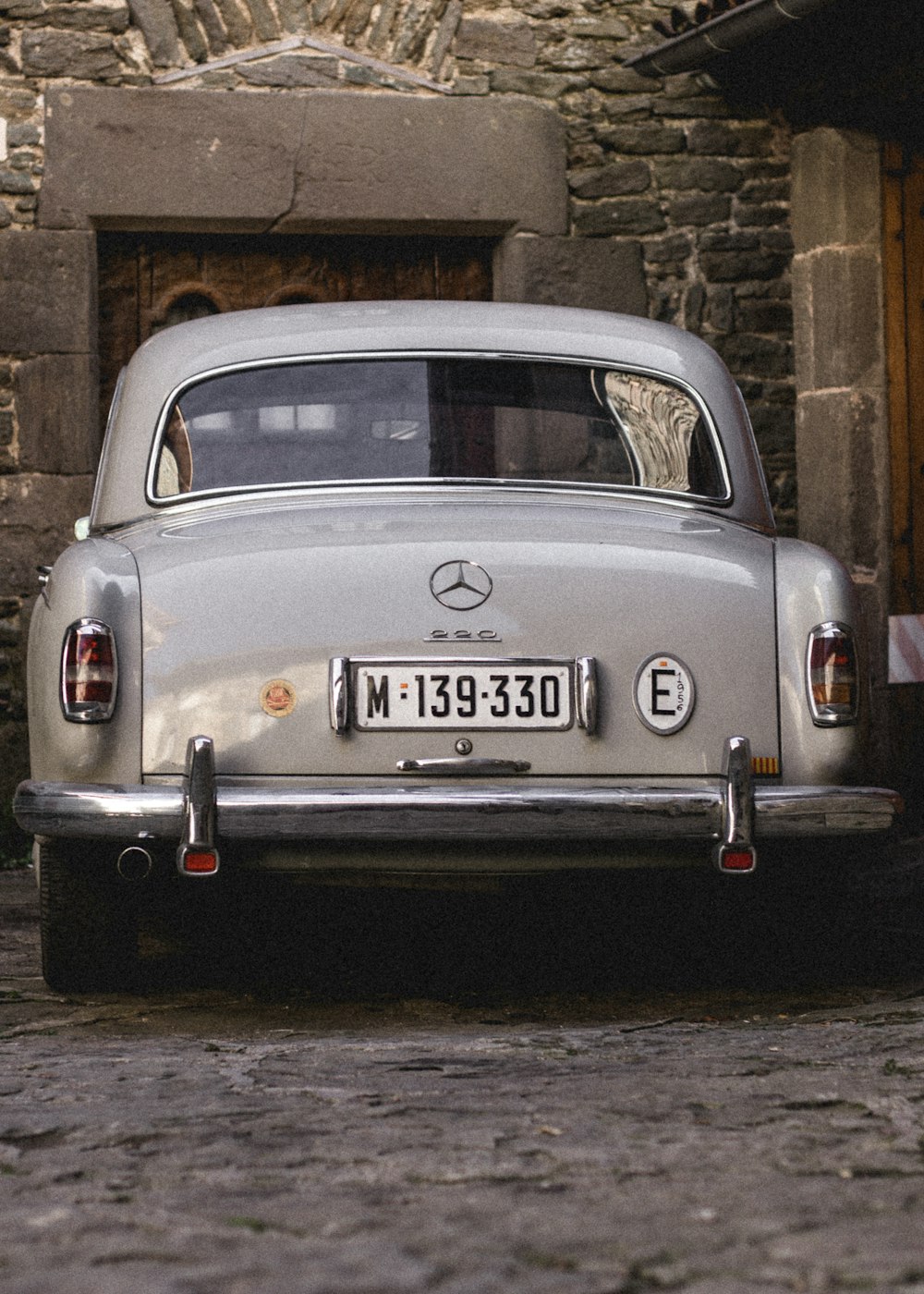 gray Mercedes-Benz 300SL parked beside building