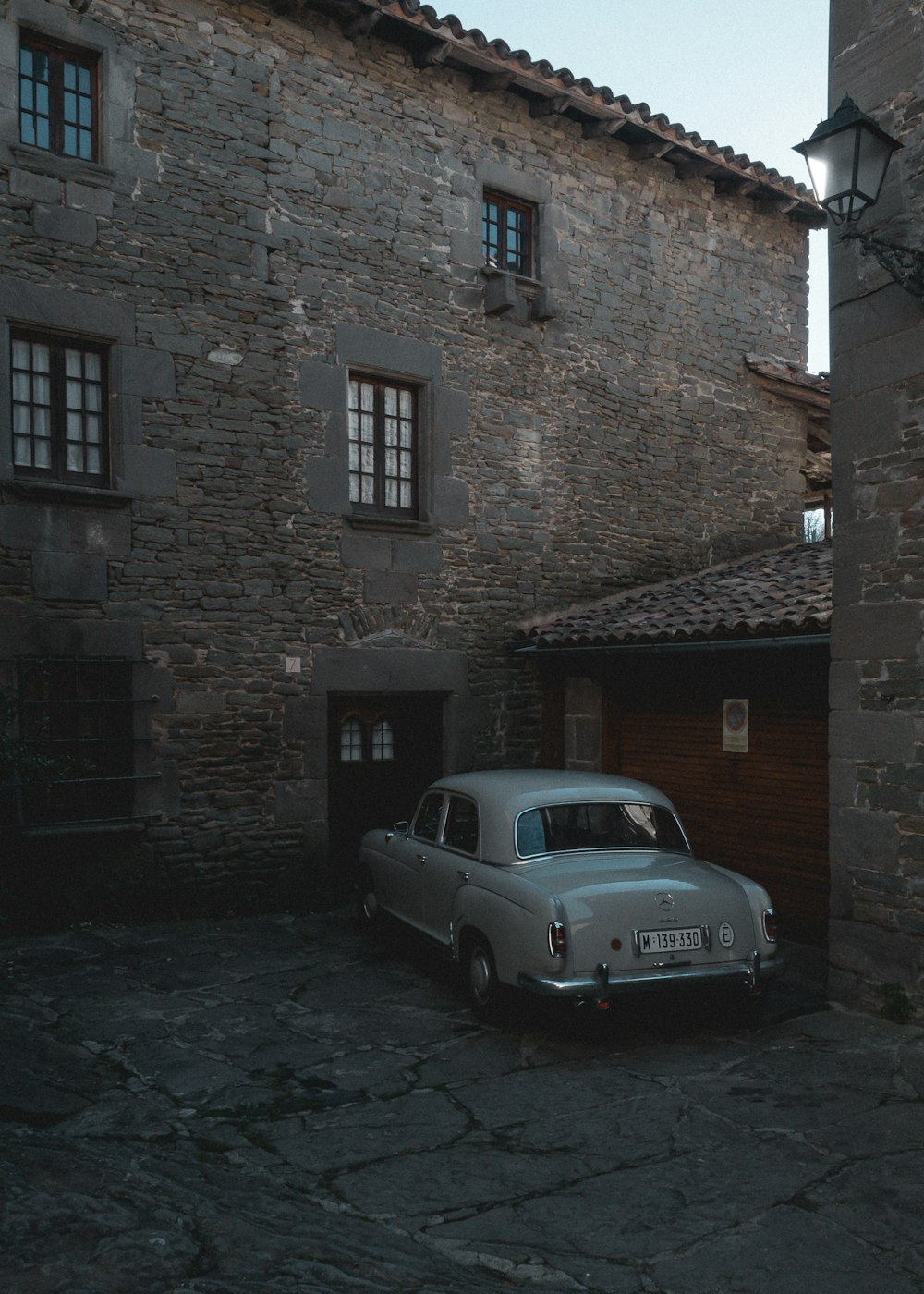 gray sedan parking in front of garage