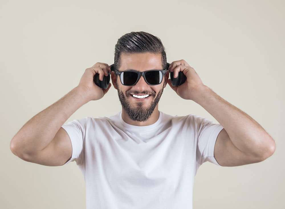 man wearing sunglasses and wireless headphones