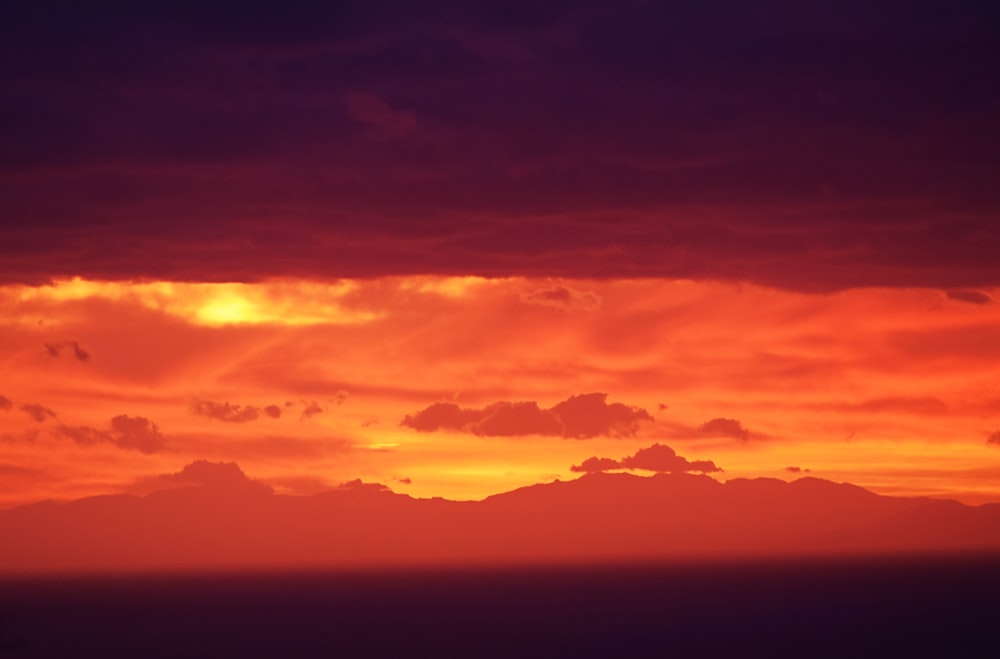 mountain under clouds during sunset