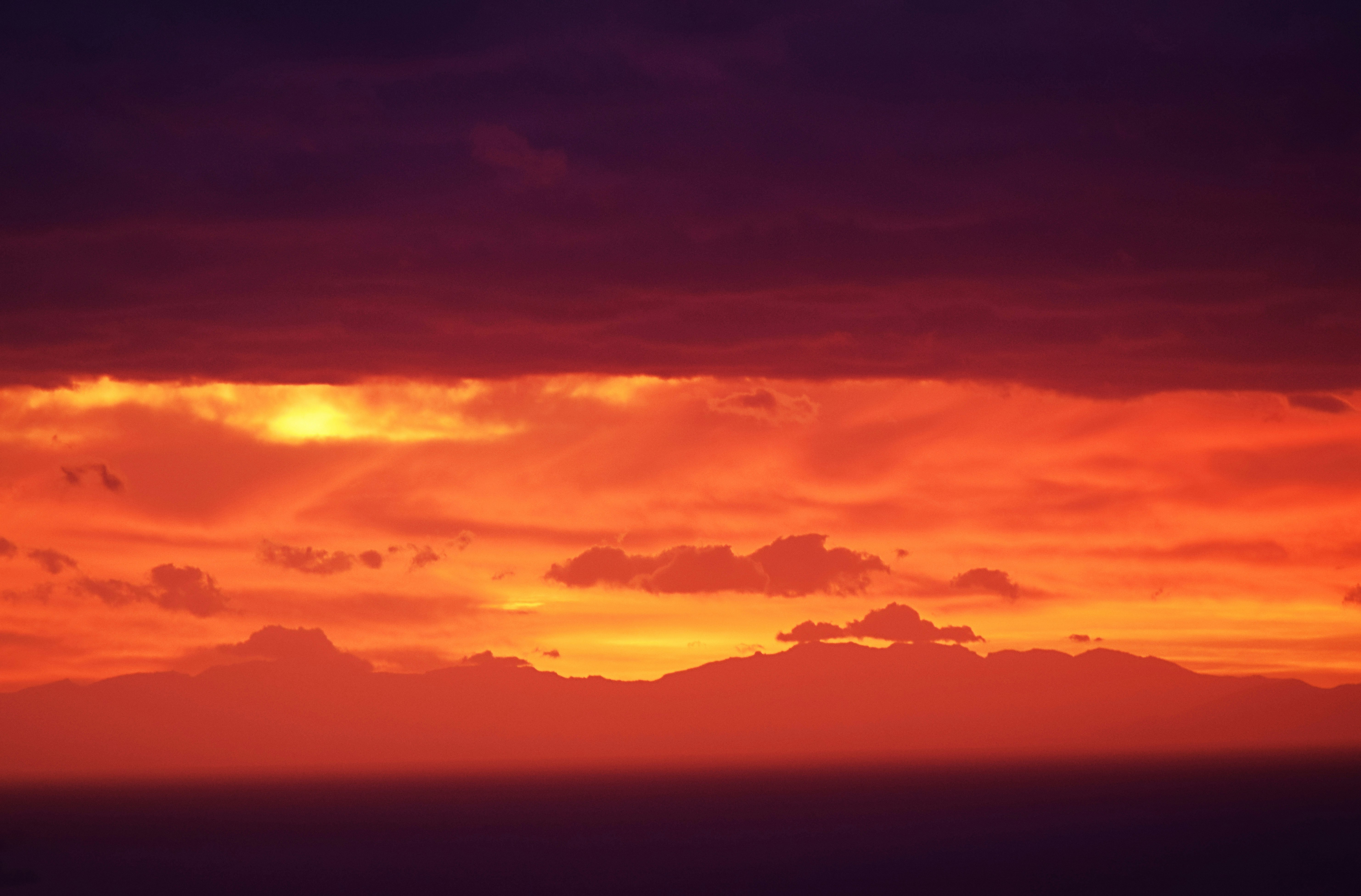 mountain under clouds during sunset