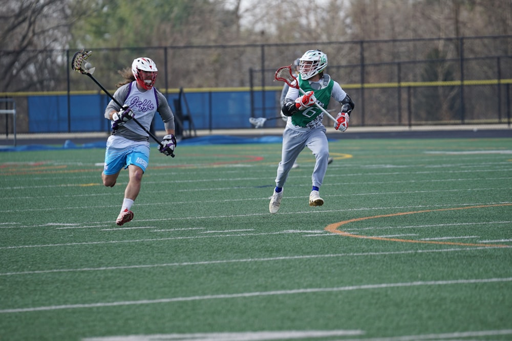 two people playing lacrosse during daytime