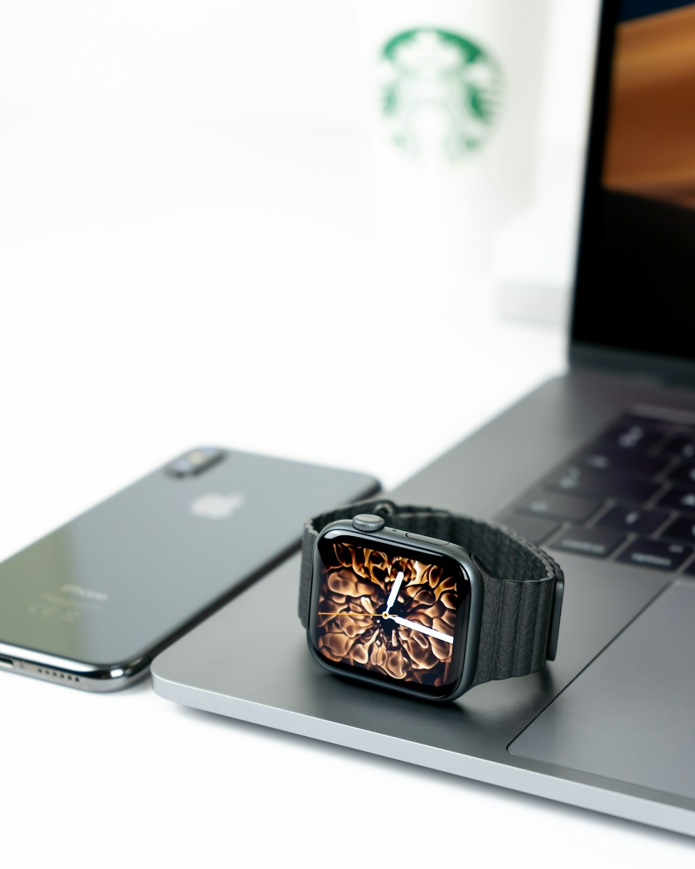 Apple Watch sur ordinateur portable à côté de l’iPhone X