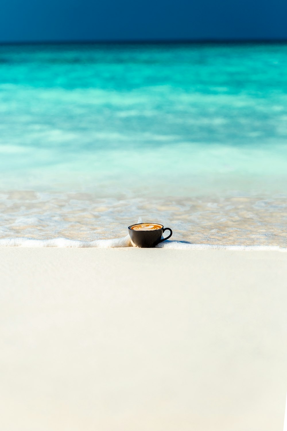 Taza de cerámica negra en el mar