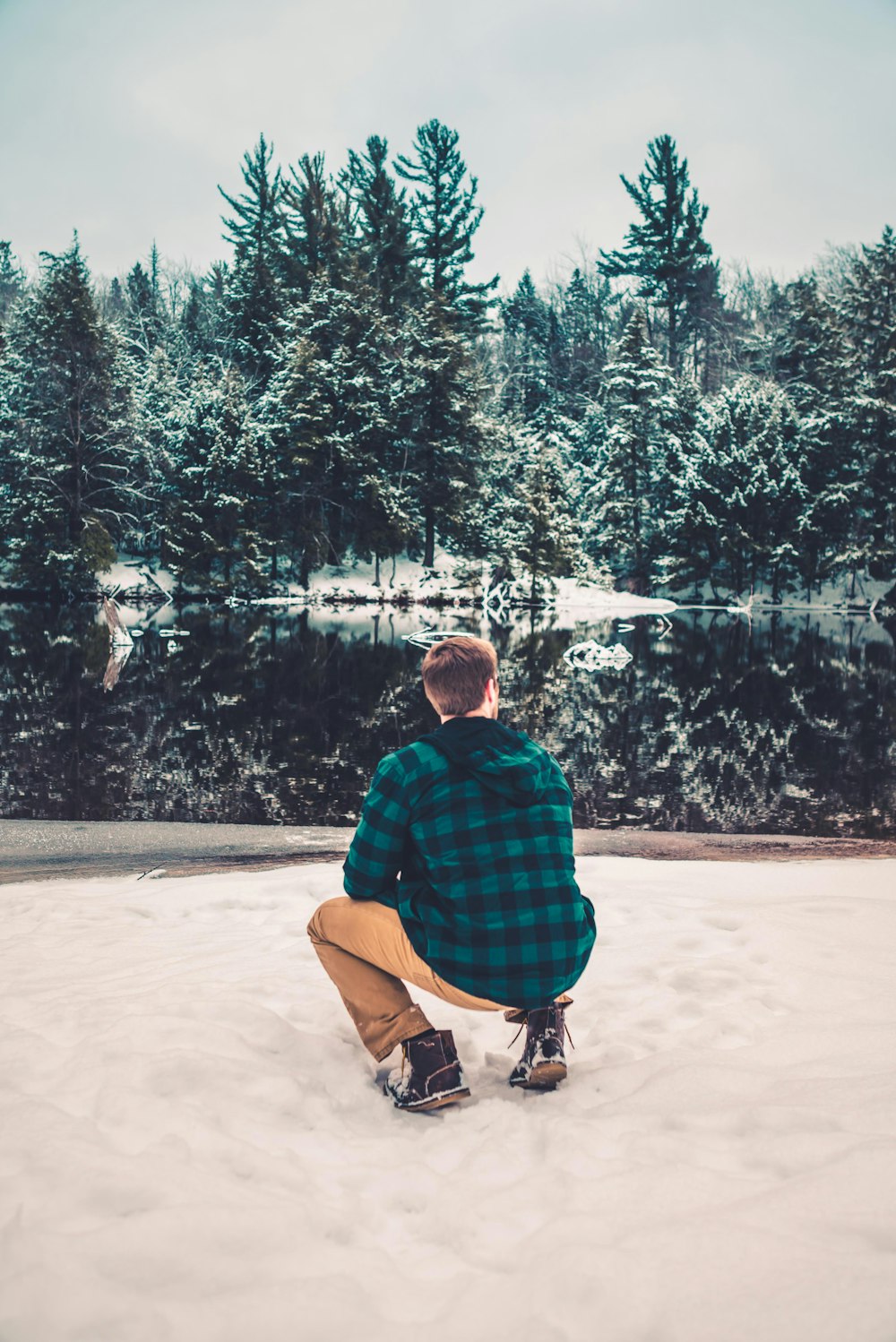 man sitting on snow field
