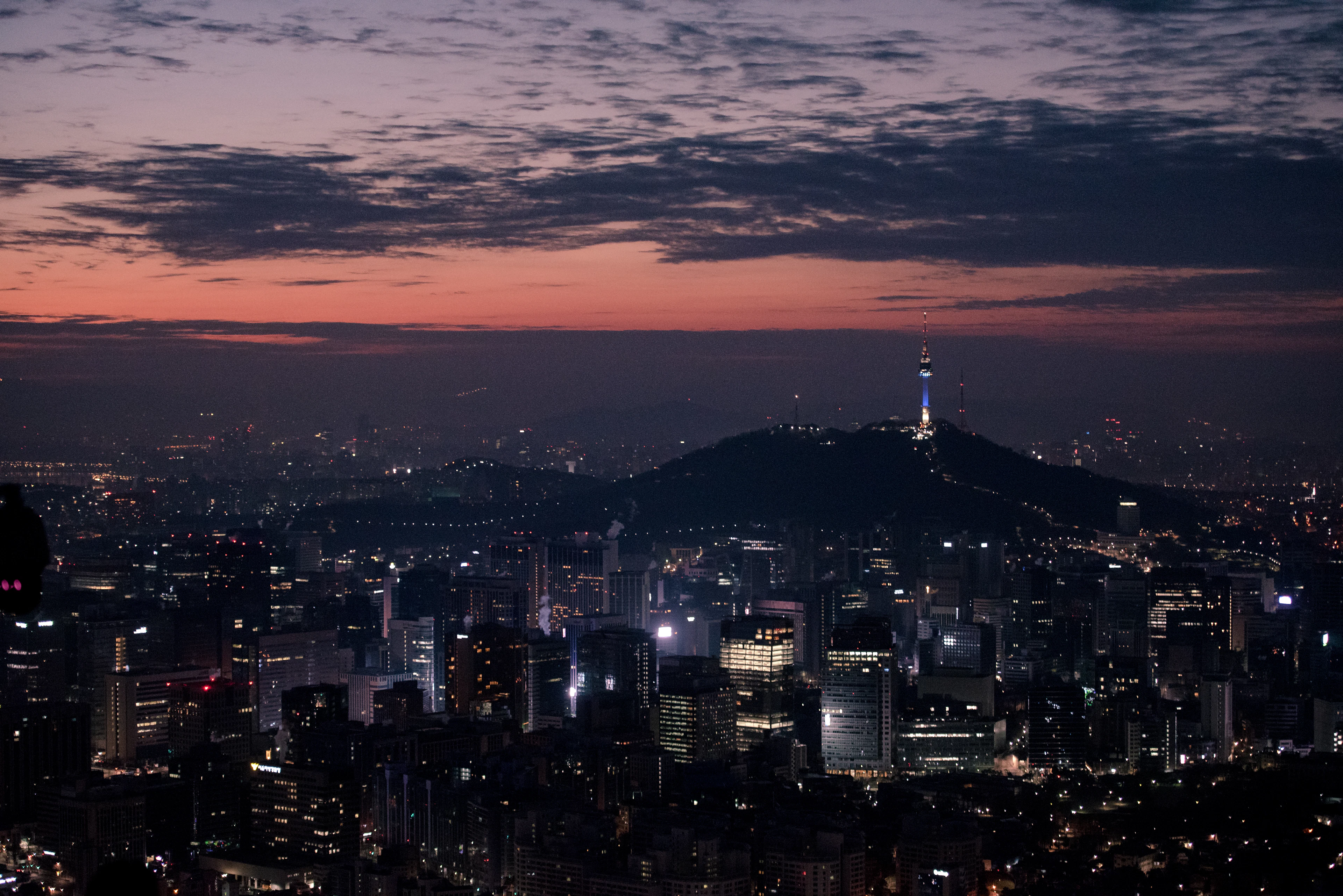 The Seoul skyline at dusk with N Seoul Tower glowing on the summit of Namsan mountain
