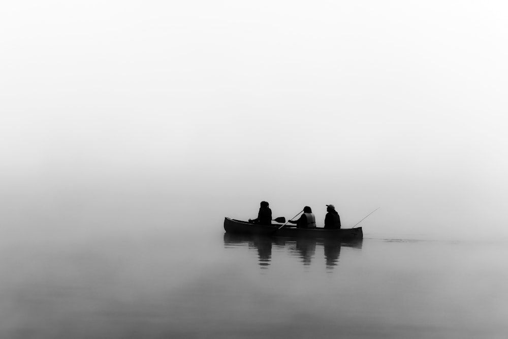 3 men on boat fishing in placid waters