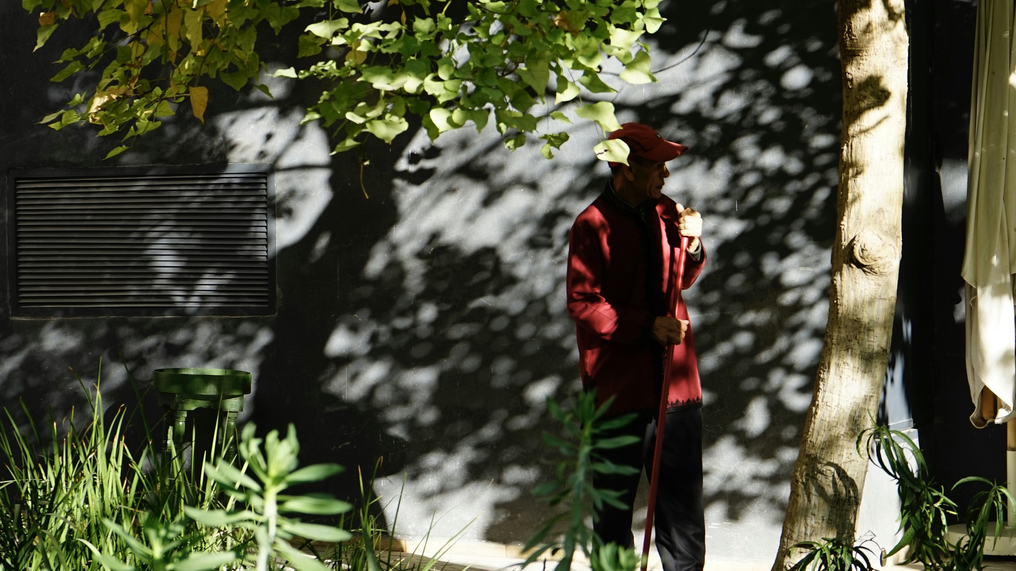 person wearing red jacket near wall