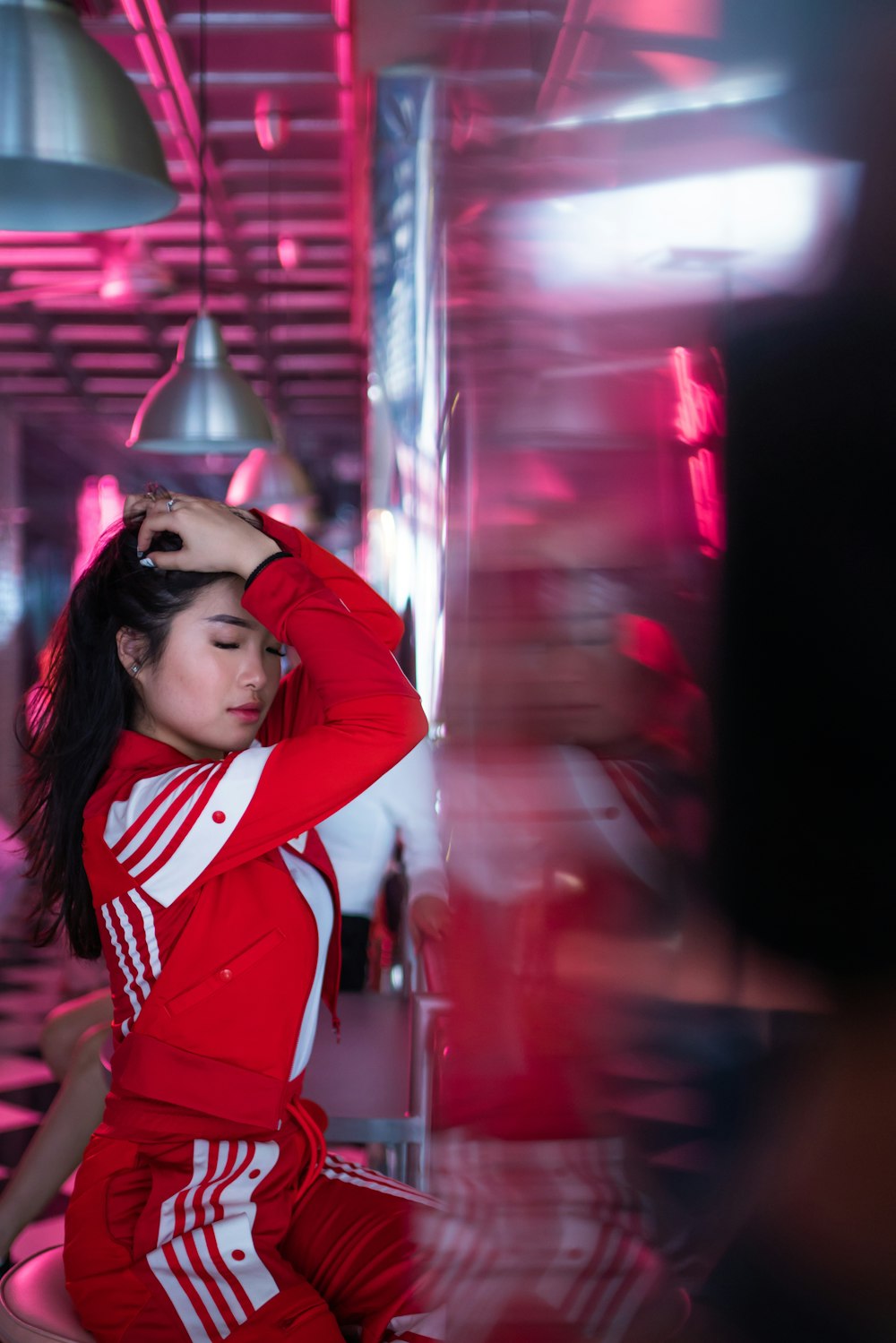 woman in red tracksuit sitting on chair inside building