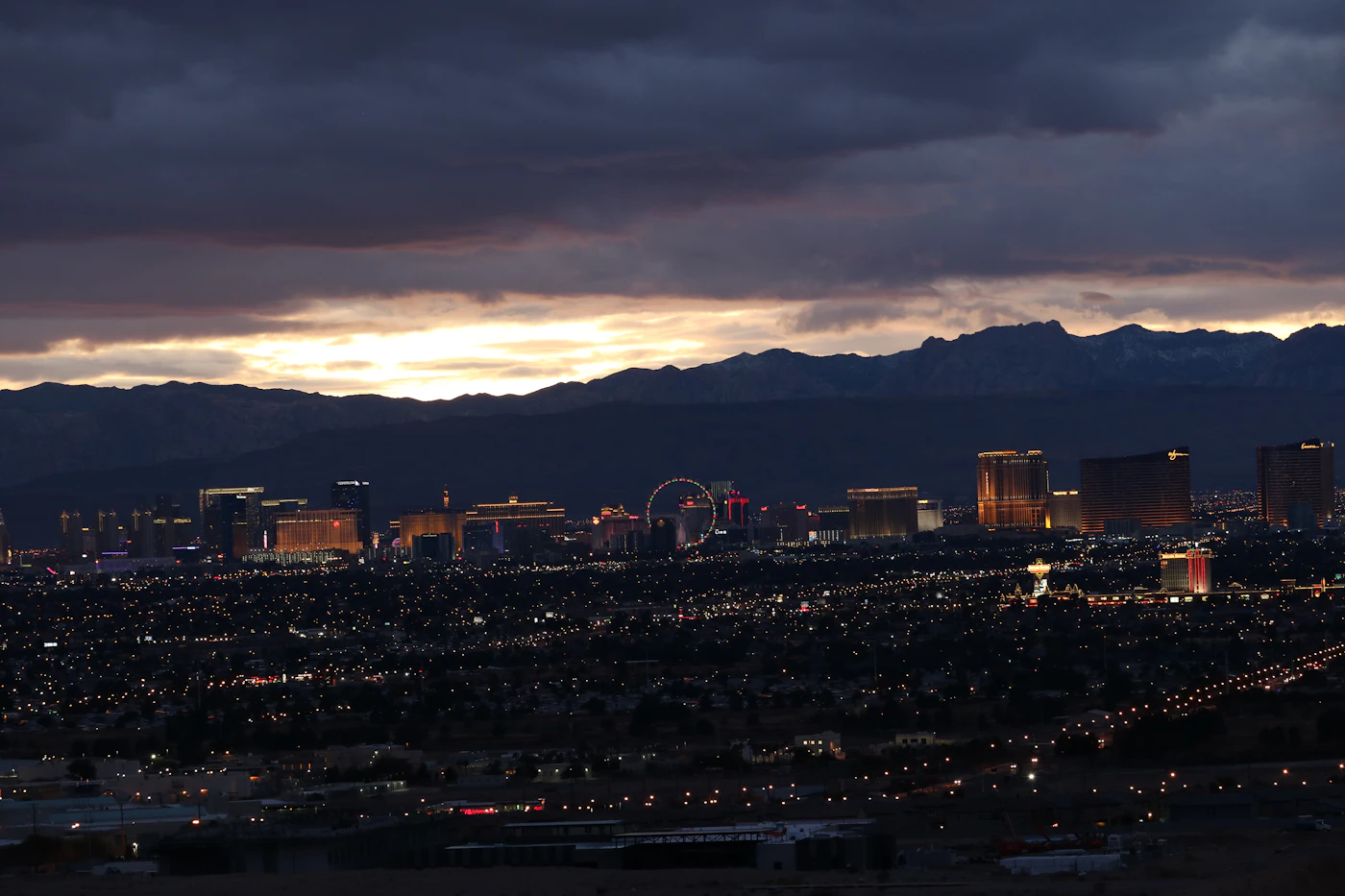 Las Vegas valley at dusk, city lights spreading toward the mountains