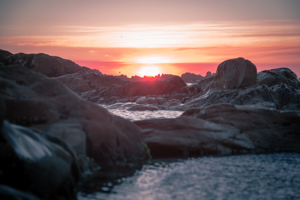 close-up photo of gray rock under orange clouds