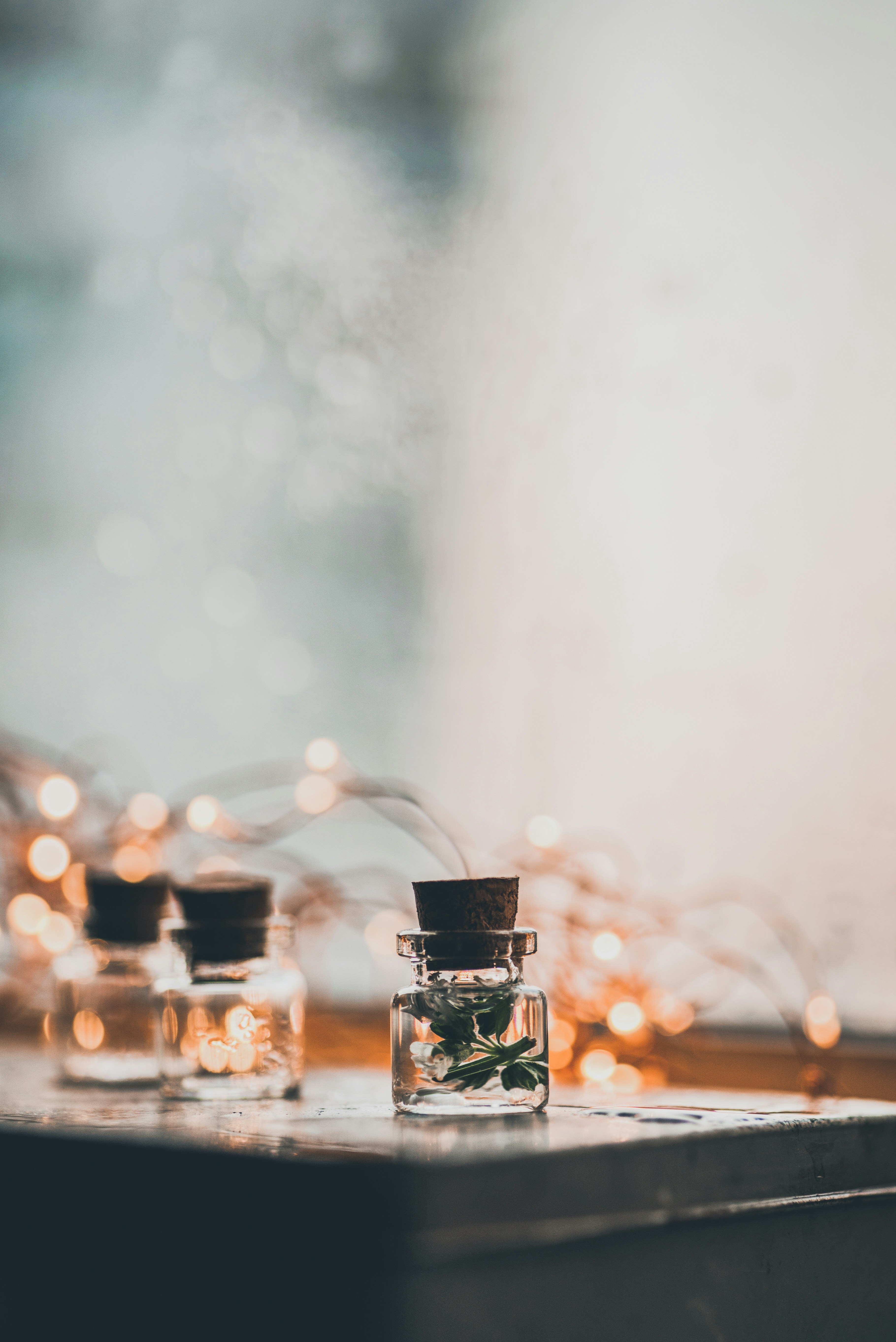 focus photography of three small glass bottle on desk