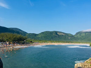 A vibrant photo of tourists enjoying a scenic beach in Lombok with a tour guide and rental vehicles nearby.