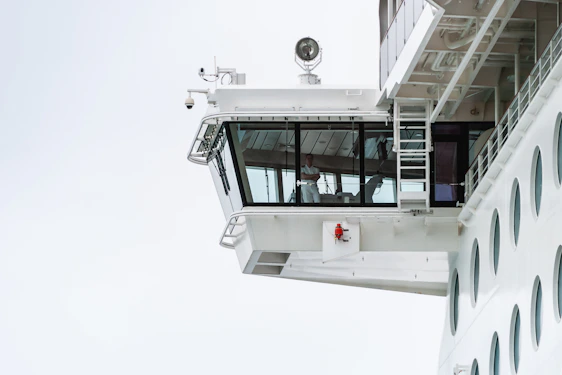 Professional maritime team collaborating onboard a modern ship bridge under clear skies.