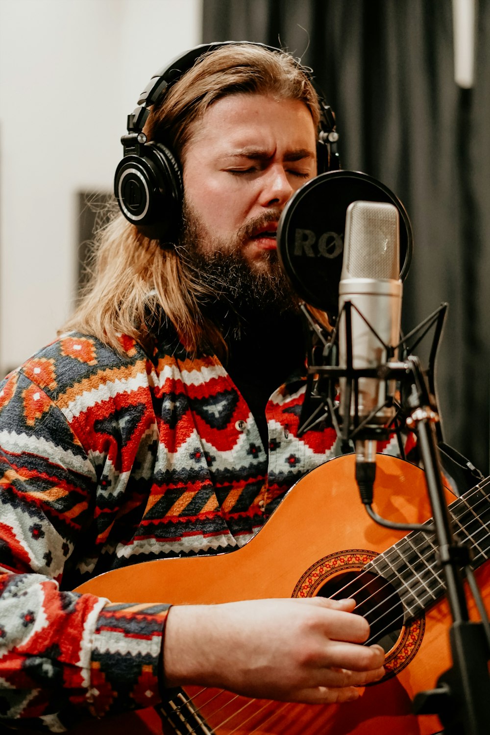 man holding guitar while singing