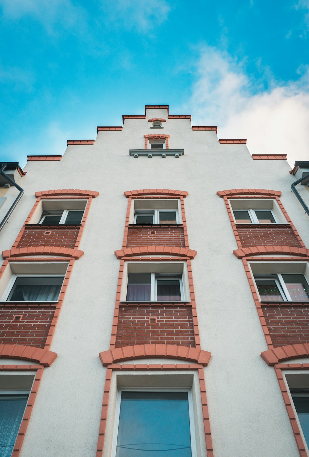 Low-Angle-Fotografie eines mehrstöckigen Gebäudes aus weißem und braunem Beton bei Tag