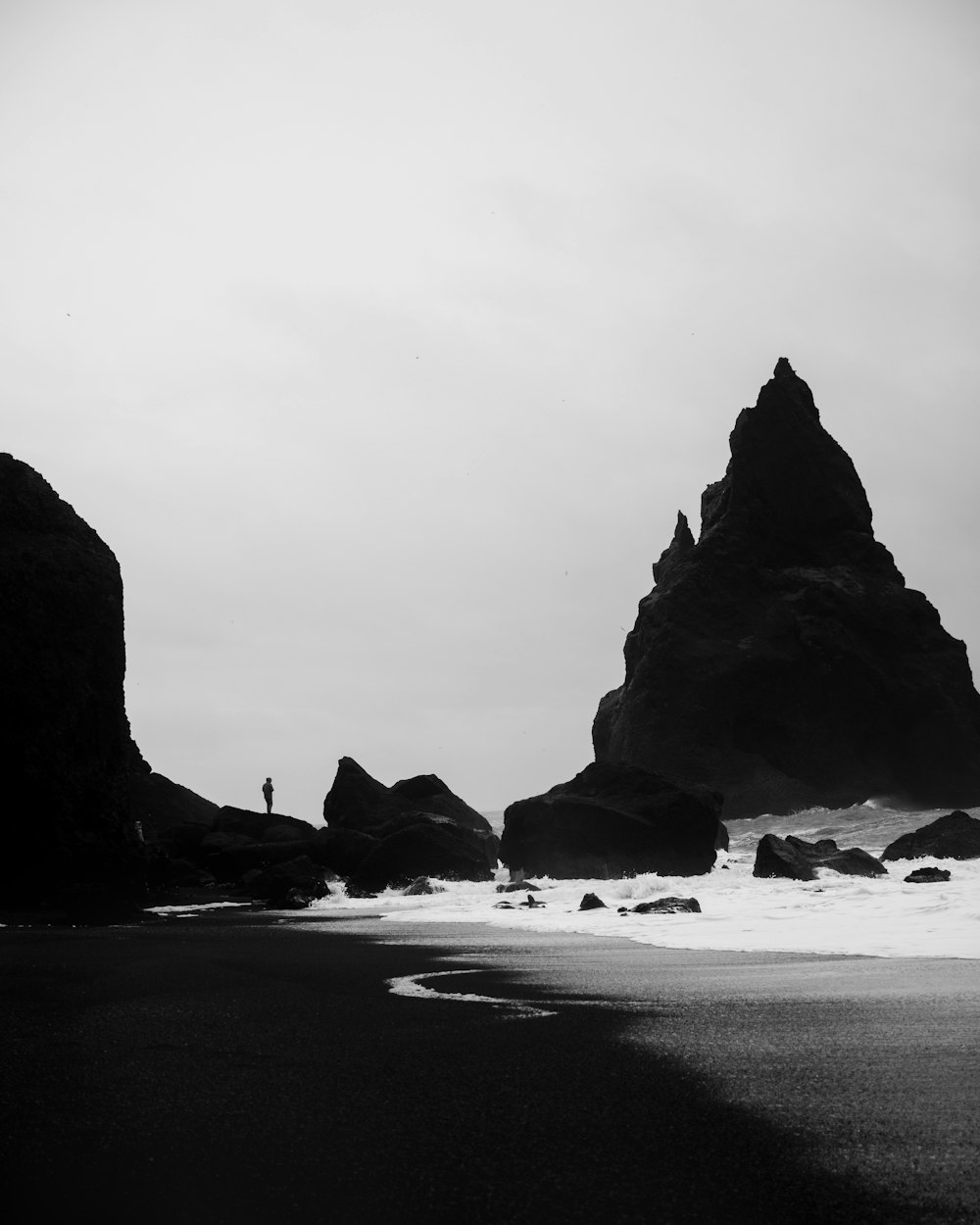 person standing on rock near body of water