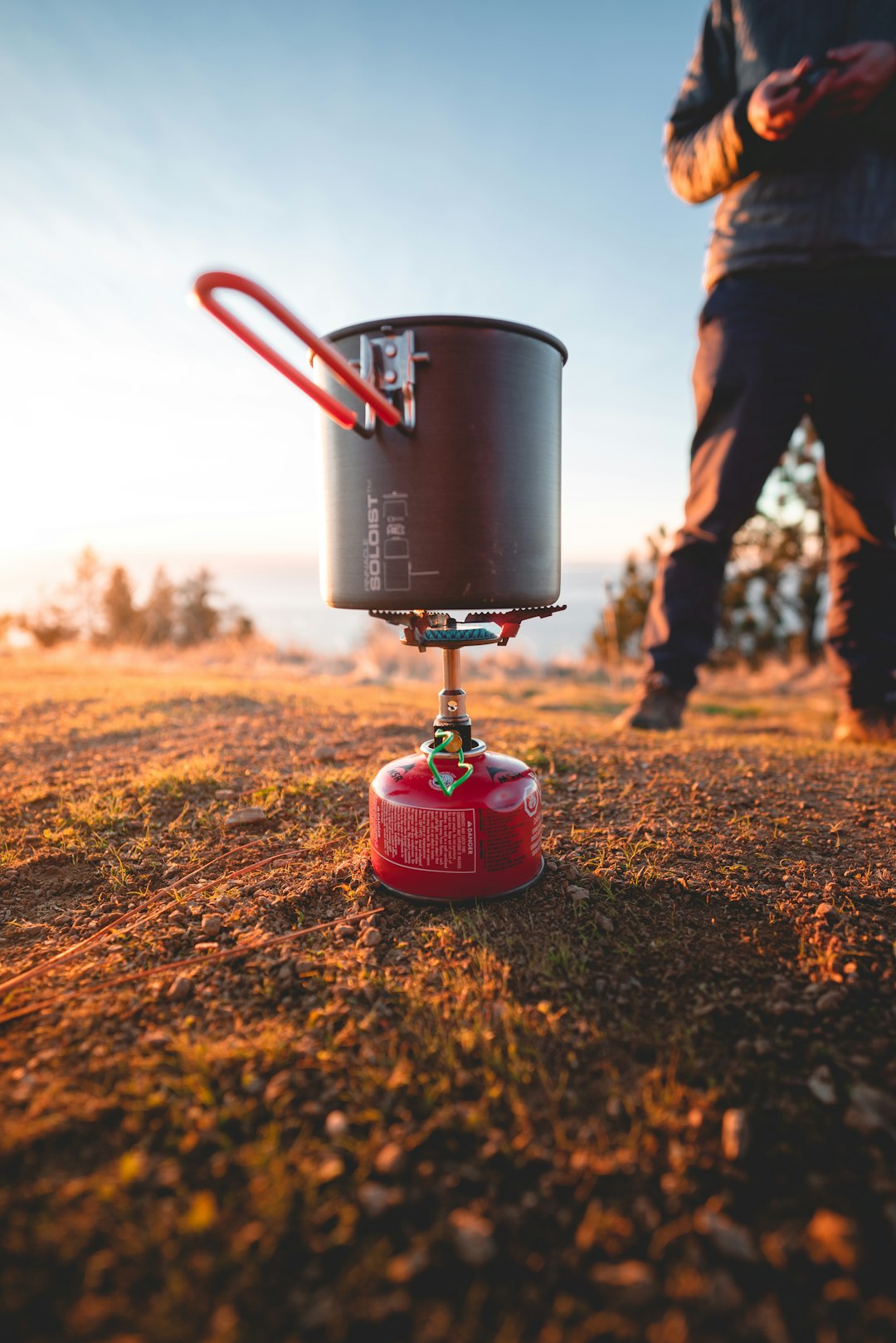 red portable gas tank and black steel pot