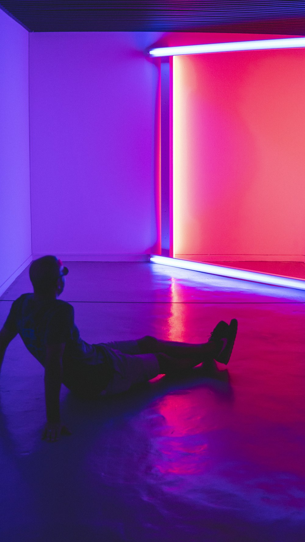 man sitting on floor facing a lighted room area