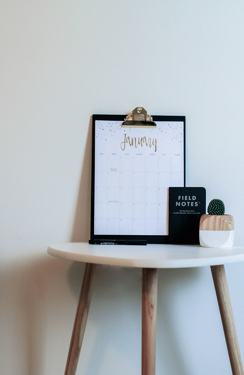 brown and white wooden table with black clipboard