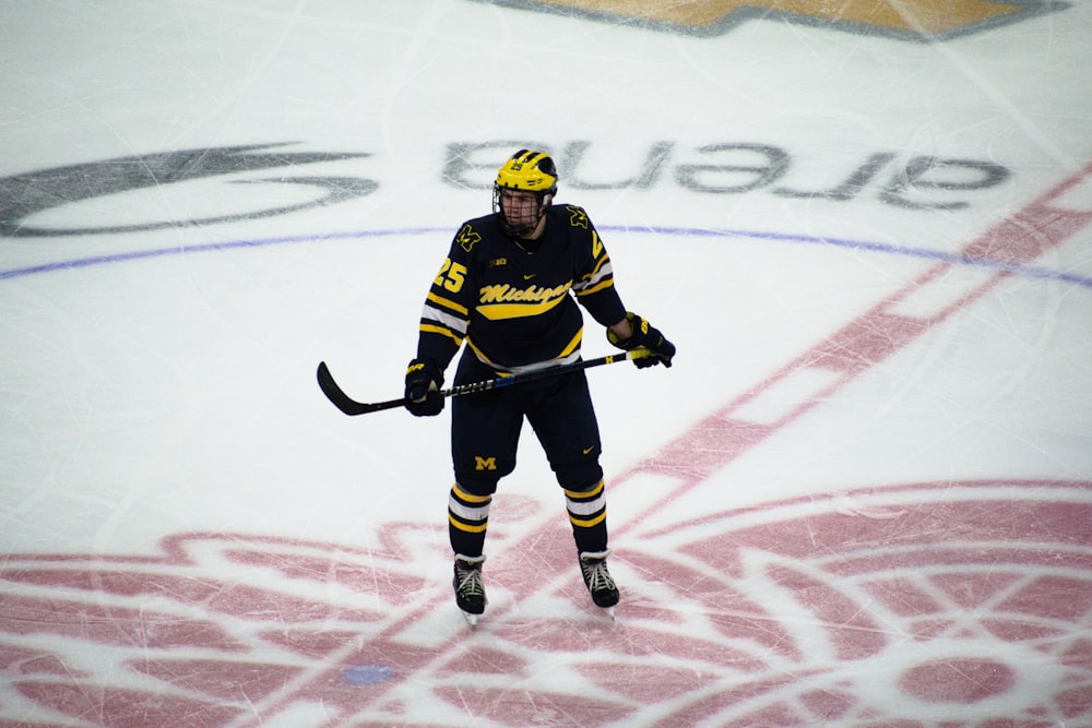 man in hockey gear holding stick on ice rink