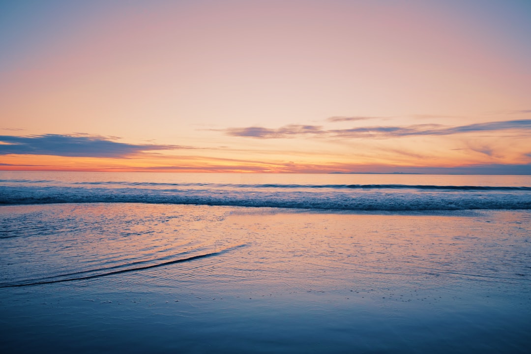 sea waves crashing on shore during golden hour