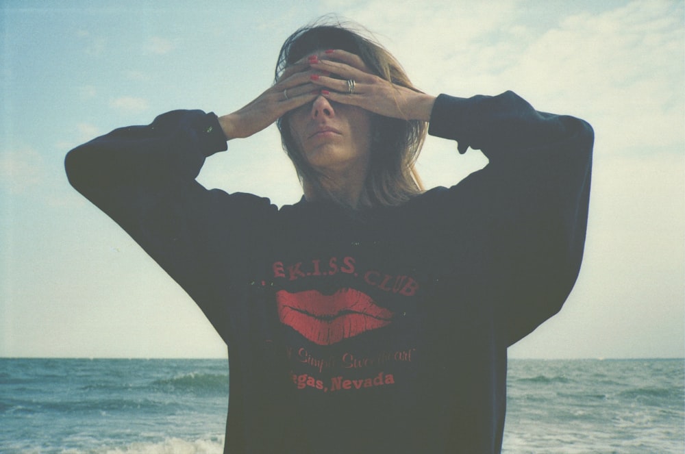 woman covering eyes by sea