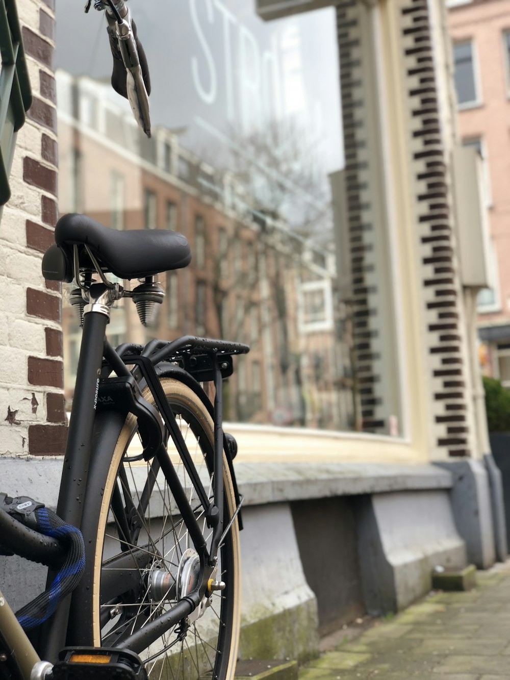 black commuter bike parked beside glass store window