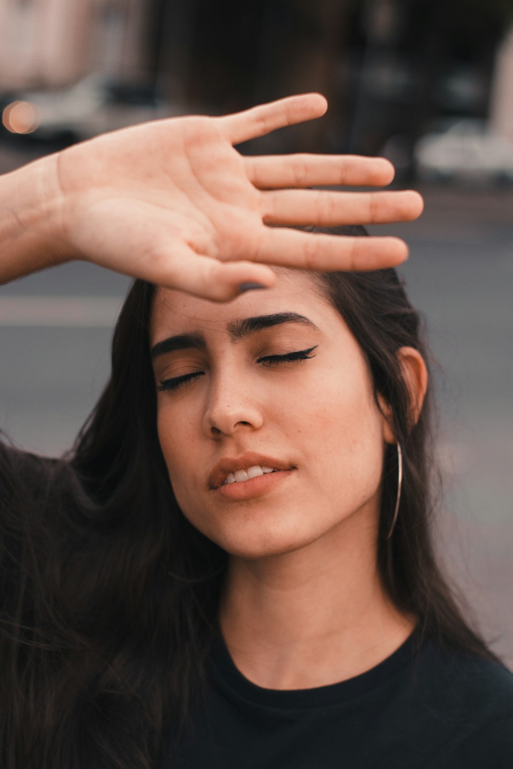 woman in black shirt with forehand on forehead