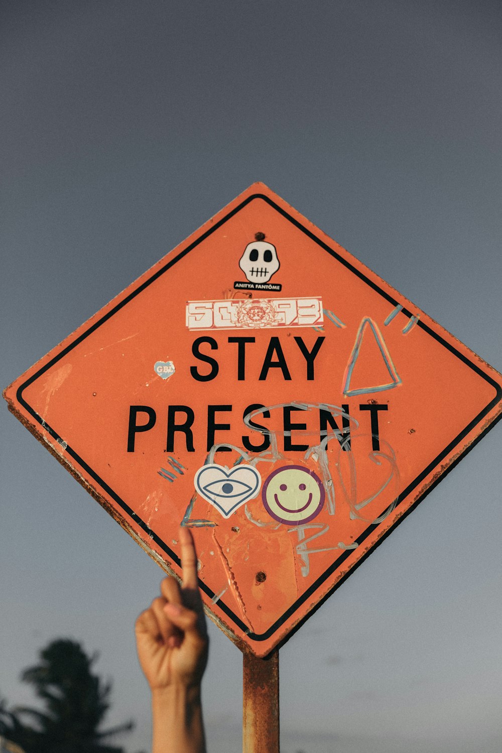 日中、Stay Present道路標識を指差す人