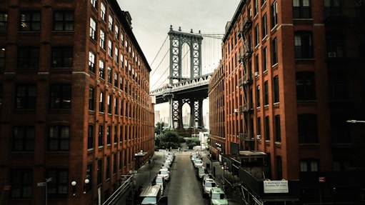 cars parked on both sides of street near bridge