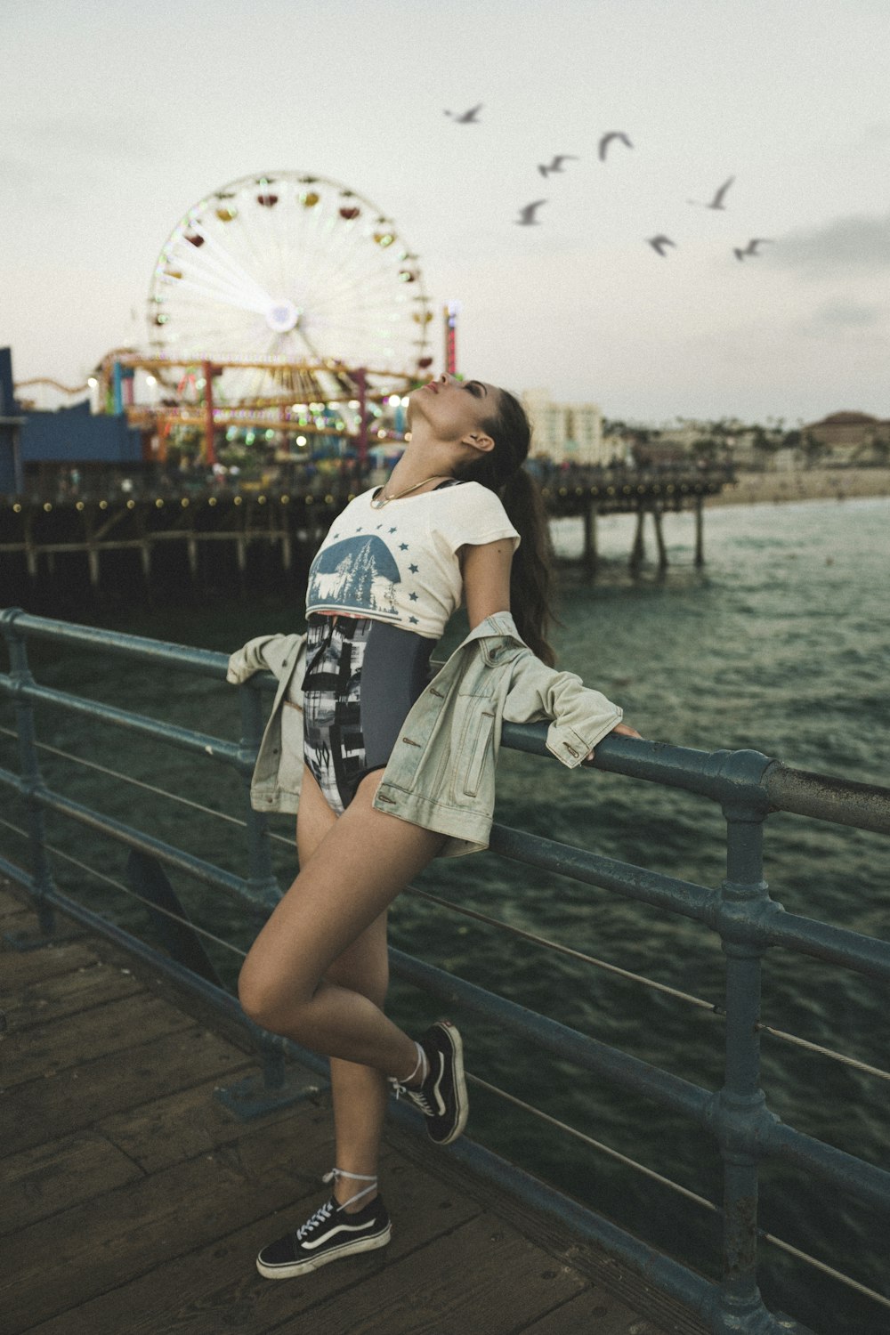 woman standing near railings viewing body of water