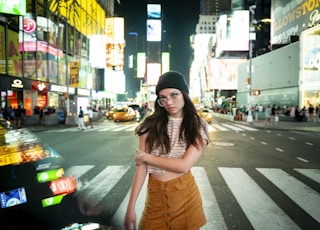 woman wearing black beanie standing across highway