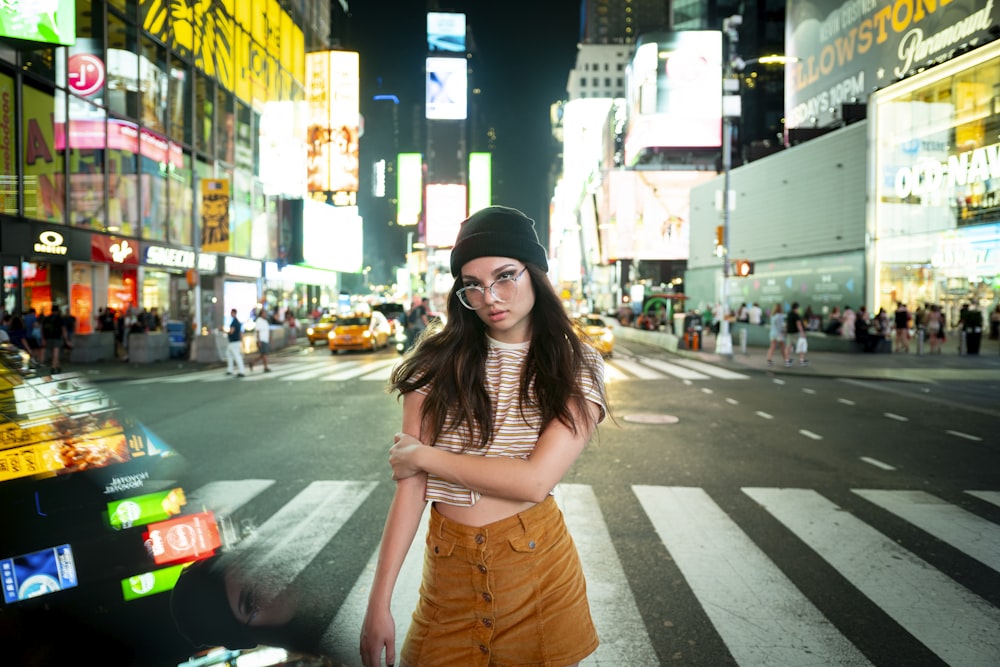 woman wearing black beanie standing across highway